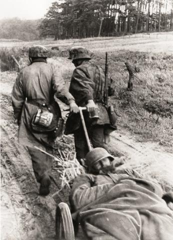 Duitse soldaten vervoeren gewonde 